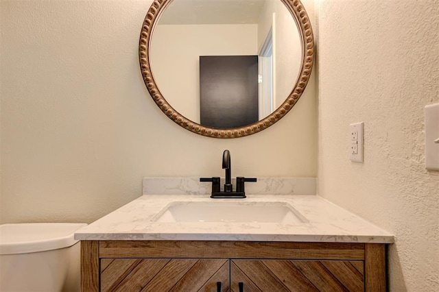1804 Foxfire Rd, Edmond, OK 73003 - half bathroom featuring a textured wall, toilet, and vanity