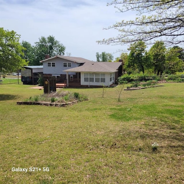back of property featuring a chimney and a lawn