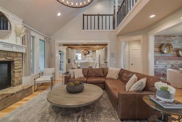 living area featuring a fireplace, wood finished floors, high vaulted ceiling, a chandelier, and recessed lighting