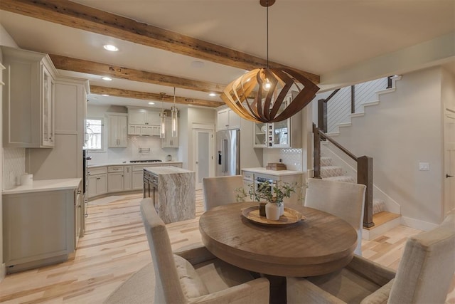 dining space featuring light wood-type flooring, recessed lighting, stairway, and beamed ceiling