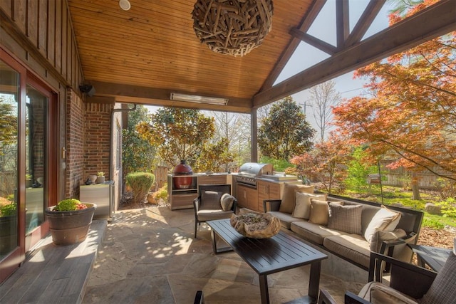 view of patio / terrace with an outdoor kitchen, fence, an outdoor living space, and a grill
