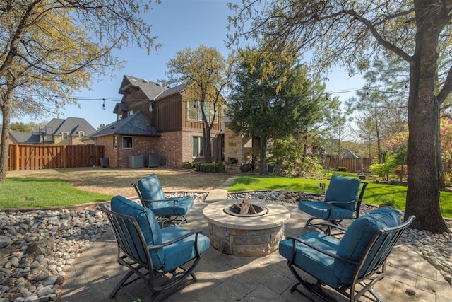 view of patio featuring fence, an outdoor fire pit, and central AC
