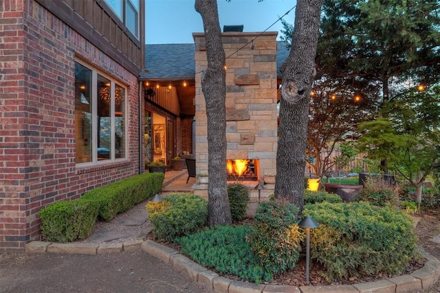 view of home's exterior featuring brick siding and roof with shingles