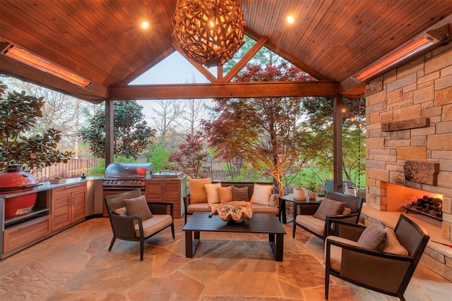 view of patio with area for grilling, exterior kitchen, a gazebo, and an outdoor living space with a fireplace