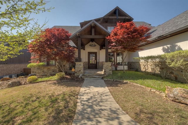 craftsman house with stucco siding, a front lawn, and stone siding