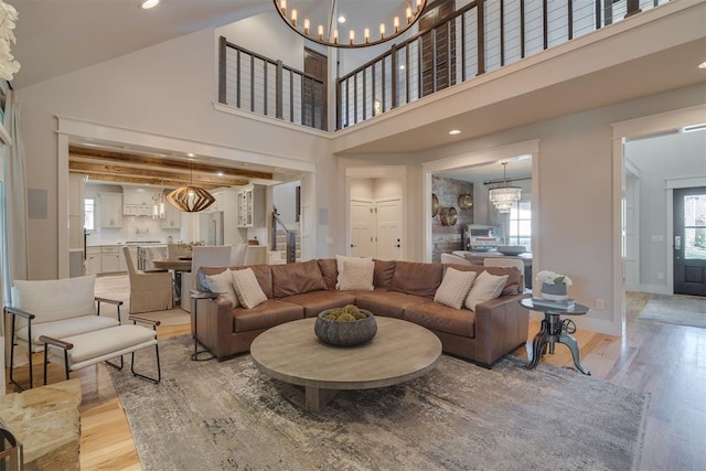 living room featuring recessed lighting, light wood-type flooring, stairs, and a notable chandelier