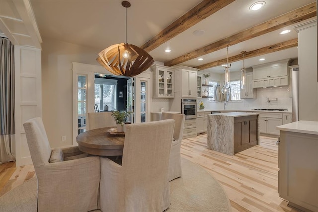dining room with light wood-style floors, beamed ceiling, and recessed lighting