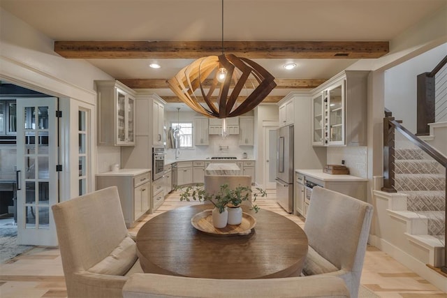 dining space featuring an inviting chandelier, recessed lighting, stairs, and beamed ceiling