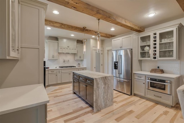 kitchen with light wood-style floors, glass insert cabinets, decorative backsplash, and stainless steel appliances