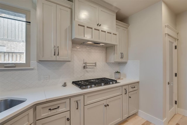 kitchen featuring light countertops, decorative backsplash, and stainless steel gas cooktop