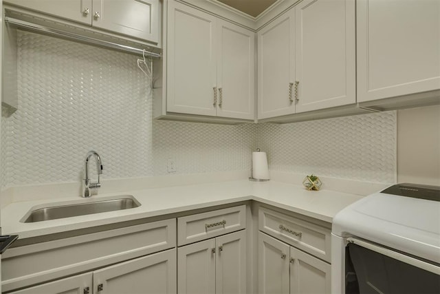 laundry room featuring a sink, washer / clothes dryer, and cabinet space