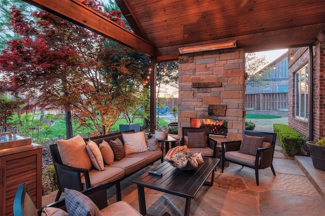 view of patio with fence and an outdoor living space with a fireplace