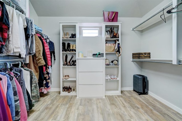 walk in closet with wood finished floors