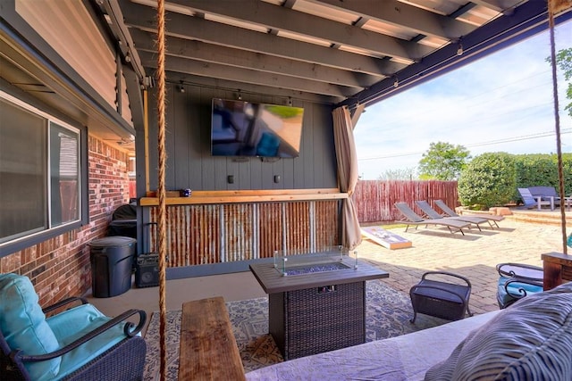 view of patio featuring fence and an outdoor living space with a fire pit