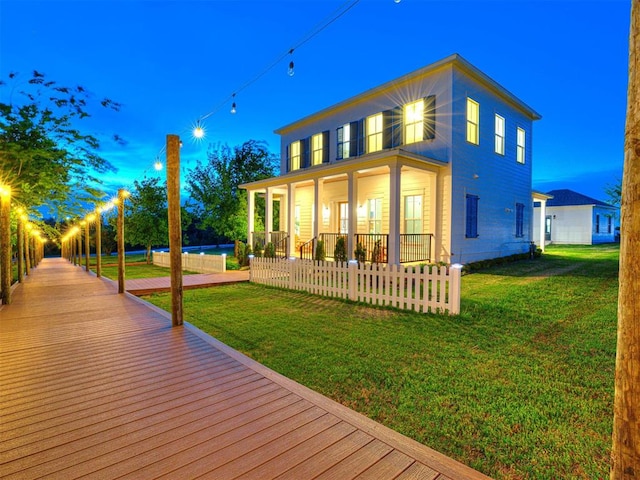 18443 Boardwalk Xing, Norman, OK 73072 - rear view of property featuring a fenced front yard, a porch, and a lawn
