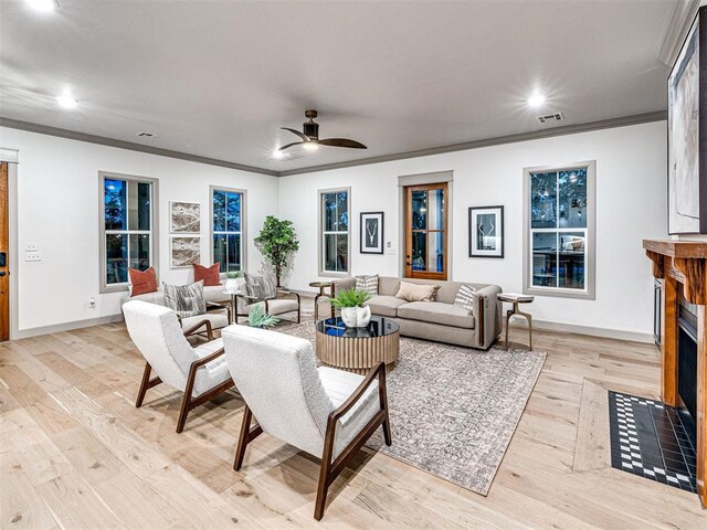 18443 Boardwalk Xing, Norman, OK 73072 - living room featuring ceiling fan, ornamental molding, a fireplace with flush hearth, and visible vents