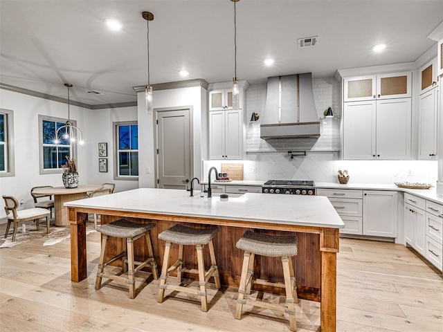 18443 Boardwalk Xing, Norman, OK 73072 - kitchen featuring a sink, wall chimney range hood, a kitchen breakfast bar, and visible vents