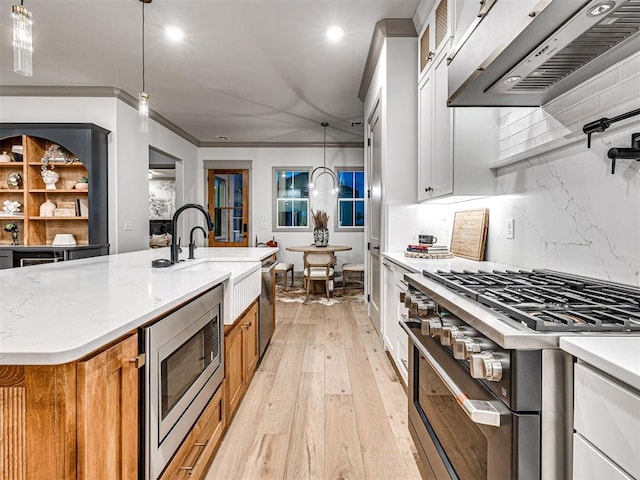 18443 Boardwalk Xing, Norman, OK 73072 - kitchen with a sink, stainless steel appliances, extractor fan, light wood-style floors, and ornamental molding