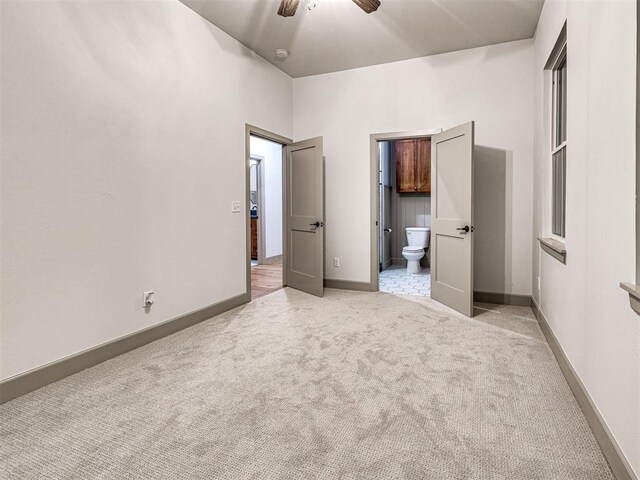 18443 Boardwalk Xing, Norman, OK 73072 - unfurnished bedroom with light colored carpet, connected bathroom, baseboards, and ceiling fan
