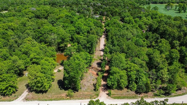 drone / aerial view featuring a wooded view
