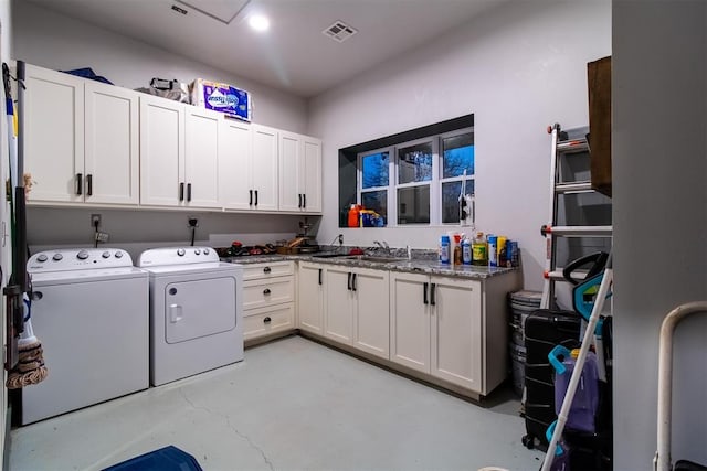 laundry room featuring cabinet space, visible vents, a sink, and washing machine and clothes dryer