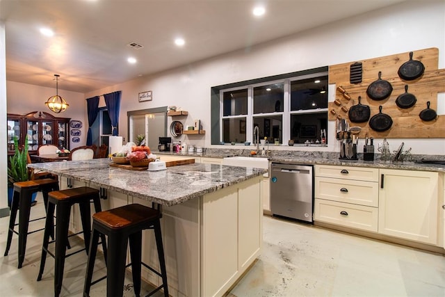 kitchen with a kitchen bar, a center island, stainless steel dishwasher, a sink, and light stone counters