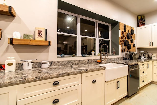 kitchen featuring dishwashing machine, light stone counters, open shelves, and a sink
