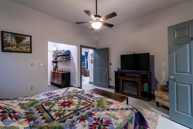 bedroom with a glass covered fireplace and ceiling fan