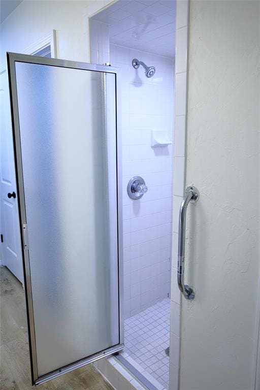 bathroom featuring a shower stall and wood finished floors