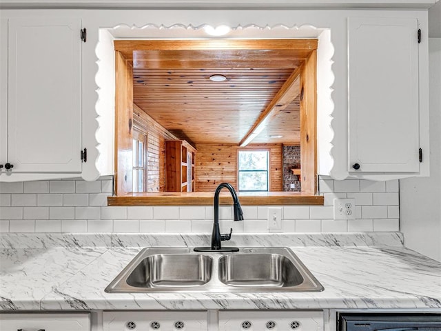 3402 Oakhurst Dr, Oklahoma City, OK 73110 - kitchen featuring wood ceiling, decorative backsplash, a sink, and white cabinets