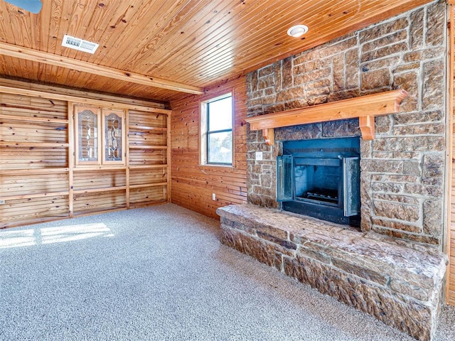 3402 Oakhurst Dr, Oklahoma City, OK 73110 - unfurnished living room with a stone fireplace, wooden walls, carpet floors, wooden ceiling, and visible vents