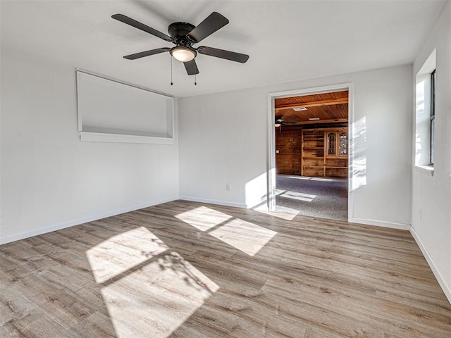 3402 Oakhurst Dr, Oklahoma City, OK 73110 - spare room featuring wood finished floors, a ceiling fan, baseboards, and wood walls