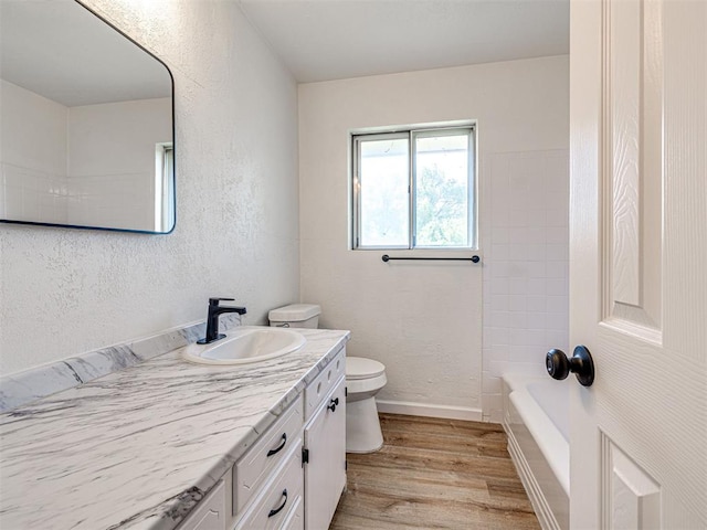 3402 Oakhurst Dr, Oklahoma City, OK 73110 - bathroom with toilet, a textured wall, vanity, and wood finished floors
