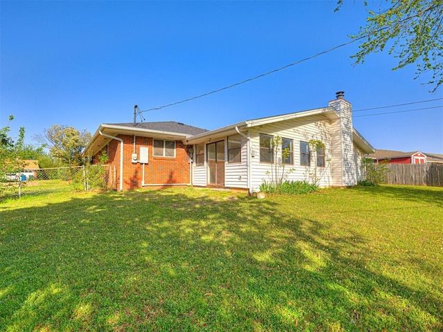 3402 Oakhurst Dr, Oklahoma City, OK 73110 - rear view of house with a fenced backyard, a chimney, brick siding, a lawn, and a sunroom