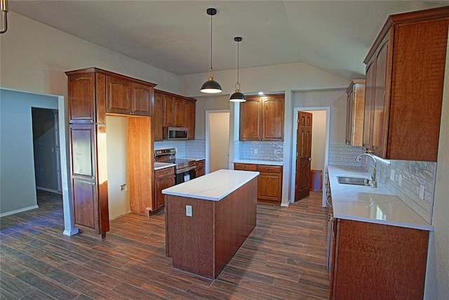 kitchen featuring stainless steel appliances, a sink, vaulted ceiling, a kitchen island, and dark wood-type flooring