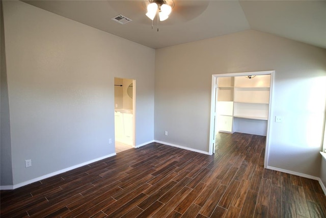 empty room featuring vaulted ceiling, ceiling fan, dark wood finished floors, baseboards, and visible vents