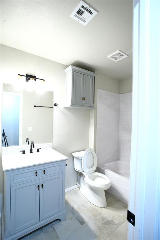 bathroom featuring baseboards, visible vents, toilet, and vanity