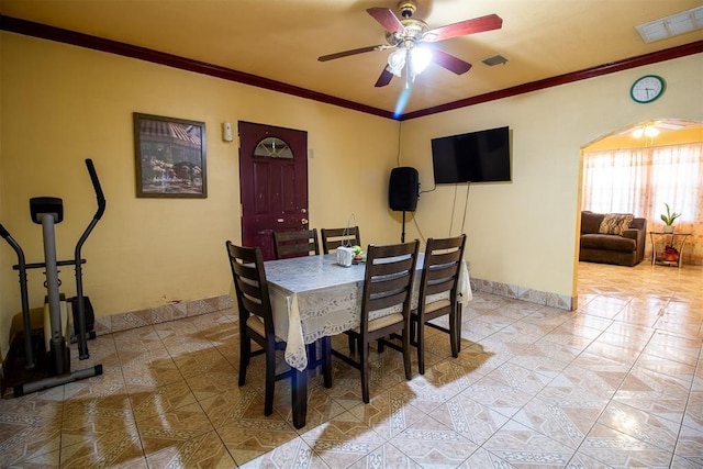 tiled dining room with ornamental molding, a ceiling fan, and visible vents