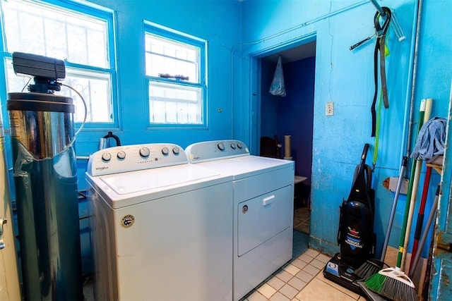 clothes washing area featuring washing machine and dryer, laundry area, and light tile patterned floors