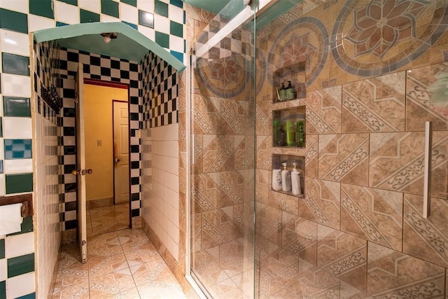 bathroom with tile walls and a shower stall