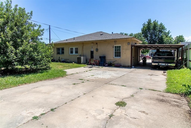 view of front of property featuring central AC, driveway, an attached carport, and brick siding