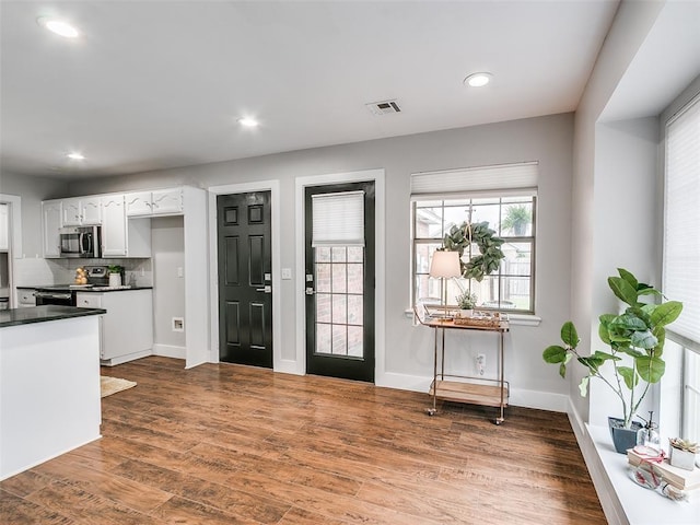 entryway with dark wood-type flooring, visible vents, recessed lighting, and baseboards
