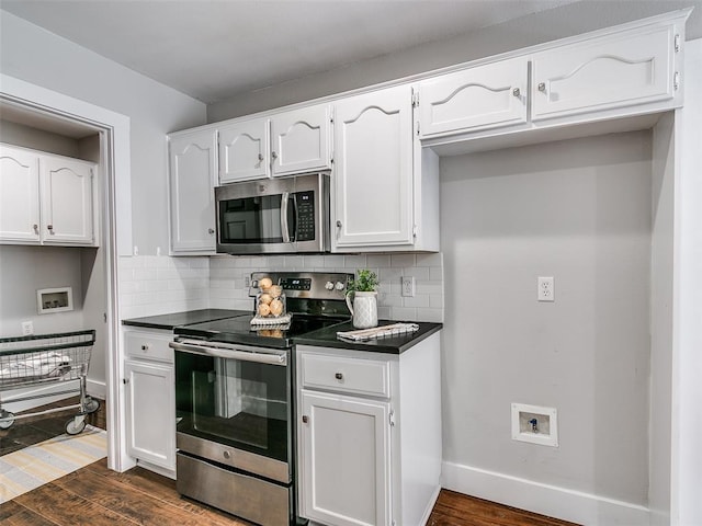 kitchen featuring dark countertops, white cabinets, appliances with stainless steel finishes, and dark wood-type flooring