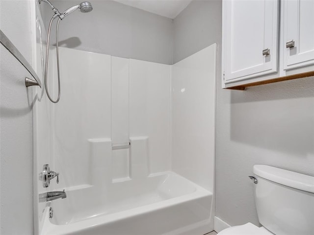 bathroom with bathing tub / shower combination and toilet