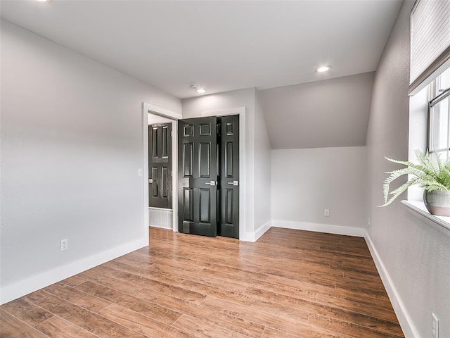 unfurnished room with recessed lighting, wood finished floors, and baseboards