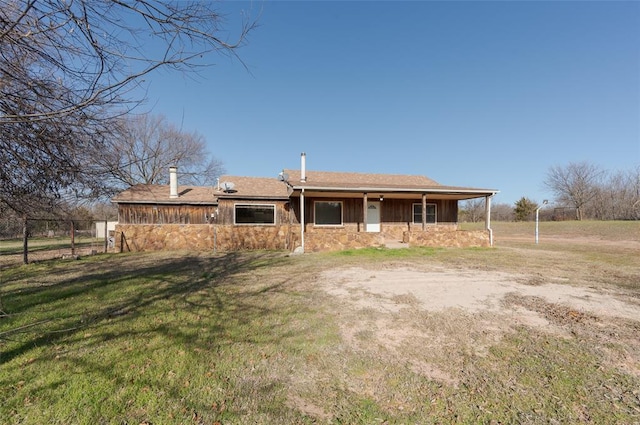 back of house featuring a yard and stone siding