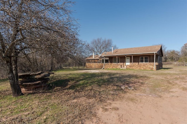 view of front of house featuring stone siding, a porch, and a front yard