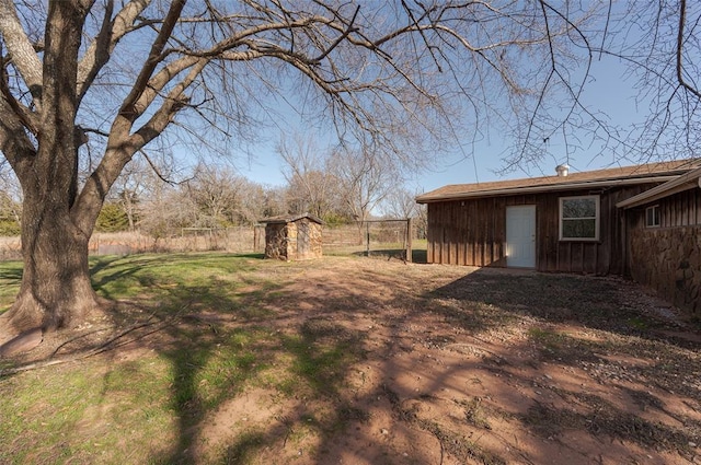 view of yard featuring fence, an outdoor structure, and a shed
