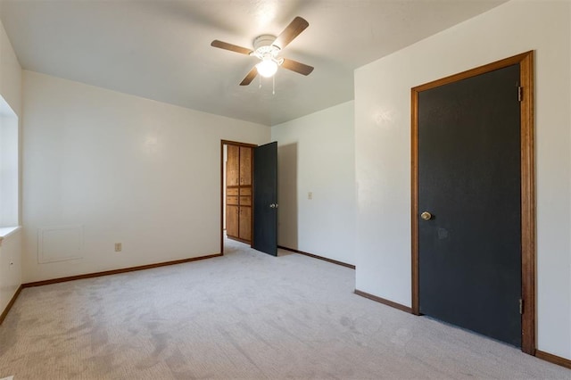 spare room with ceiling fan, baseboards, and light carpet