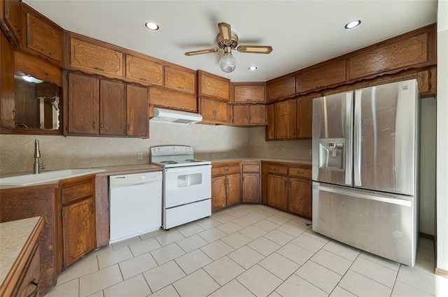 kitchen with a sink, extractor fan, a ceiling fan, white appliances, and brown cabinets